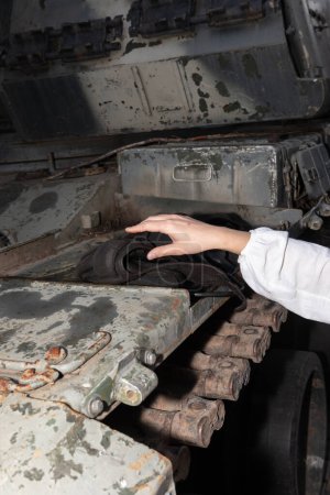Téléchargez les photos : KYIV, UKRAINE - 24 août 2023 : Une jeune femme a touché les restes d'un char russe - en image libre de droit
