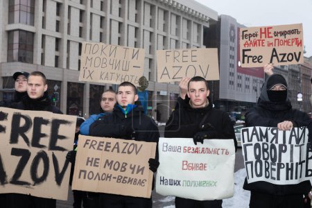 Foto de KYIV, UCRANIA - 10 de diciembre de 2023: Manifestación por la libertad de Azov en apoyo de los prisioneros de guerra ucranianos. Un grupo de jóvenes son vistos entre los participantes del mitin con pancartas - No te calles - el cautiverio mata - Imagen libre de derechos