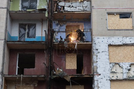 Téléchargez les photos : KYIV, UKRAINE - 05 janvier 2024 : Des volontaires et des résidents nettoient les débris et montent à bord des fenêtres du bloc résidentiel touché par un missile russe à Kiev, en Ukraine - en image libre de droit