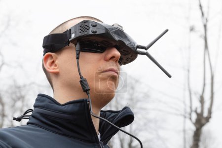 Téléchargez les photos : LVIV, UKRAINE - 11 février 2024 : Un jeune homme porte des lunettes de réalité virtuelle lors d'une séance d'entraînement aux commandes de vol d'un drone FPV - en image libre de droit
