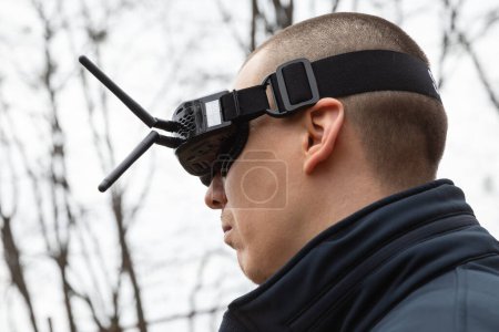Téléchargez les photos : LVIV, UKRAINE - 11 février 2024 : Un jeune homme porte des lunettes de réalité virtuelle lors d'une séance d'entraînement aux commandes de vol d'un drone FPV - en image libre de droit