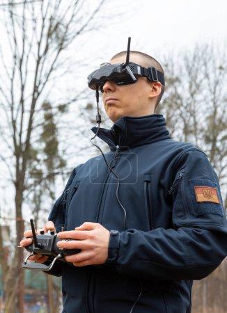 Téléchargez les photos : LVIV, UKRAINE - 11 février 2024 : Un jeune homme est vu portant des lunettes de réalité virtuelle et une télécommande pendant l'entraînement au vol d'un drone FPV - en image libre de droit