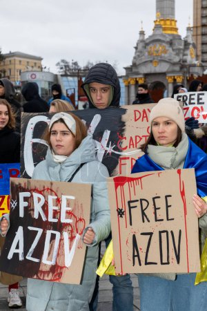 Photo for KYIV, UKRAINE - Feb. 18, 2024: Young people with Free Azov placards are seen during a rally in the central square of Ukraine's capital city - Royalty Free Image