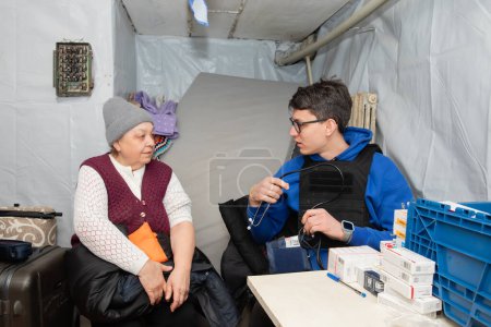 Téléchargez les photos : SIVERSK, DONETSK REG., UKRAINE - mars 2024 : Une femme locale consulte un médecin de la mission de volontaires Frida Ukraine - en image libre de droit