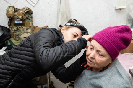 Téléchargez les photos : SIVERSK, DONETSK REG., UKRAINE - mars 2024 : Un médecin de la mission de volontaires Frida Ukraine effectue des procédures médicales sur des résidents locaux âgés en quête d'assistance médicale - en image libre de droit