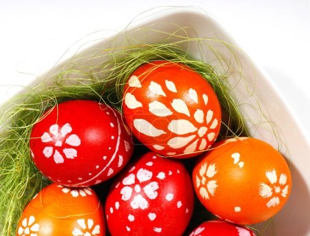 Photo for Red and orange easter eggs in a white plate - Royalty Free Image