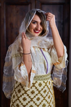 Foto de Mujer rumana joven en traje popular novia tradicional en una casa vintage - Imagen libre de derechos