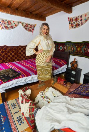 Photo for Young Romanian woman in traditional bride popular costume in a vintage home - Royalty Free Image