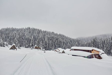 Foto de Casa de madera o granero en las montañas nevadas durante el invierno - Imagen libre de derechos