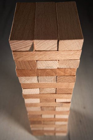 Photo for Stack of wooden blocks in a game of Jenga on a table - Royalty Free Image