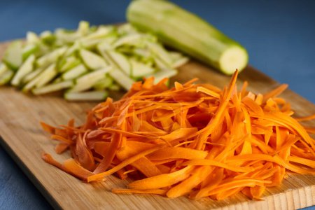 Photo for Marrow and carrot chopped and shredded on a chopping board, closeup shot - Royalty Free Image