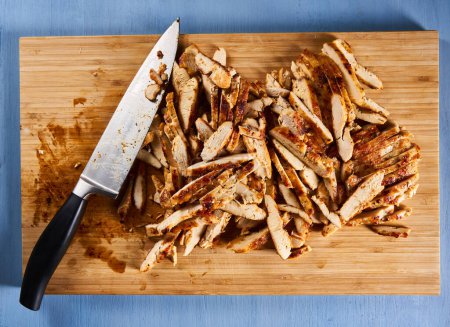 Foto de Roasted sliced chicken breast on a wooden board, ready to prepare fajitas - Imagen libre de derechos