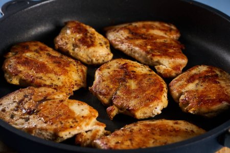 Seared chicken breast pieces in a non stick frying pan