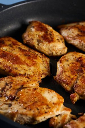 Foto de Seared chicken breast pieces in a non stick frying pan - Imagen libre de derechos