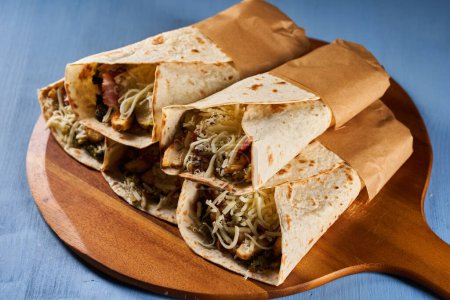 Téléchargez les photos : Burrito roll wraps on a blue wooden board - en image libre de droit