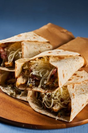 Foto de Burrito roll wraps on a blue wooden board - Imagen libre de derechos