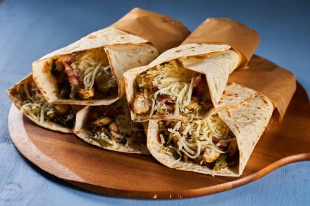 Photo for Burrito roll wraps on a blue wooden board - Royalty Free Image