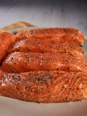 Foto de Seasoned salmon steak fillets on a plate in closeup - Imagen libre de derechos