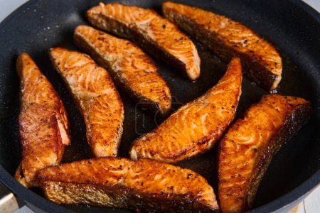 Photo for Salmon fillets in the frying pan, after cooking, seared and juicy - Royalty Free Image