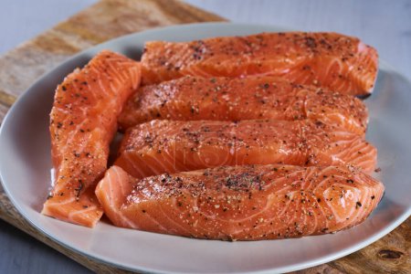Foto de Seasoned salmon steak fillets on a plate in closeup - Imagen libre de derechos