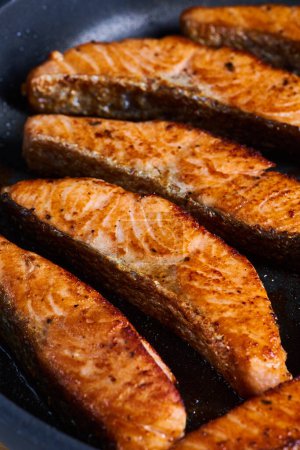 Photo for Salmon fillets in the frying pan, after cooking, seared and juicy - Royalty Free Image