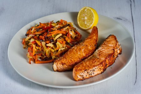Téléchargez les photos : Salmon steaks and stir fry vegetables with lemon on a plate - en image libre de droit