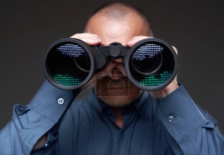 Foto de Businessman looking through binoculars on gray background - Imagen libre de derechos