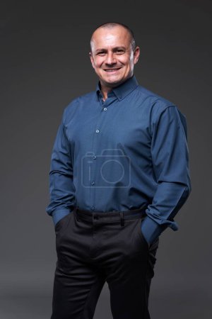 Téléchargez les photos : Homme d'affaires confiant avec les mains dans les poches sur fond gris - en image libre de droit