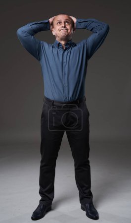 Photo for Powerless mature businessman with an I can't do anything expression on his face, gray background - Royalty Free Image