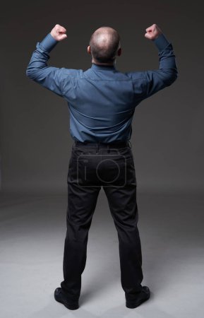 Foto de Full length shot from the back of a mature businessman on gray background - Imagen libre de derechos