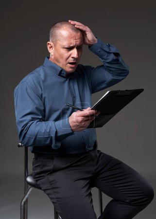 Photo for Mature businessman discovering a problem with a contract he's about to sign - Royalty Free Image