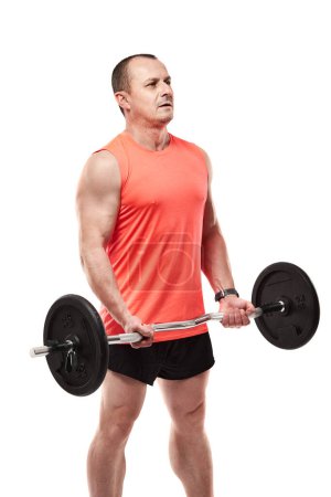 Téléchargez les photos : Homme athlétique mature en tee rose faisant de l'exercice de remise en forme avec haltère et poids, isolé sur fond blanc - en image libre de droit