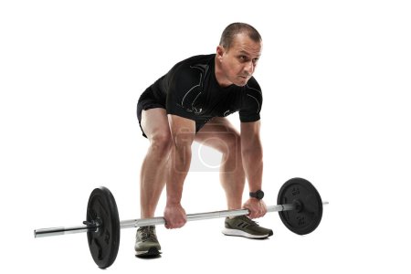 Foto de Atlético hombre de mediana edad haciendo ejercicio de fitness deadlift con barra, aislado sobre fondo blanco - Imagen libre de derechos