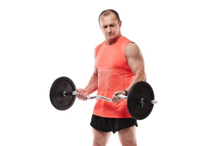 Photo for Mature athletic man in pink tee doing fitness workout with barbell and weights, isolated on white background - Royalty Free Image