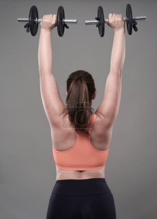 Photo for Strong confident plus size young woman working out fitness exercises with dumbbells - Royalty Free Image