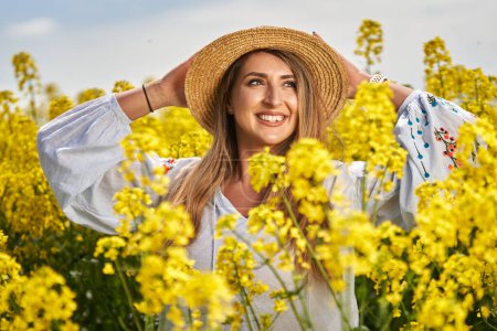 Portrait of a beautiful blonde hispanic woman in a blooming canola field