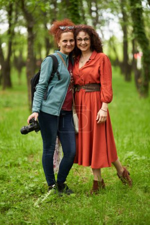 Foto de Mujer fotógrafa con cámara y su modelo femenina madura en el parque - Imagen libre de derechos