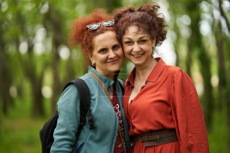 Photo for Two women friends posing together in the park, candid portrait with selective focus - Royalty Free Image