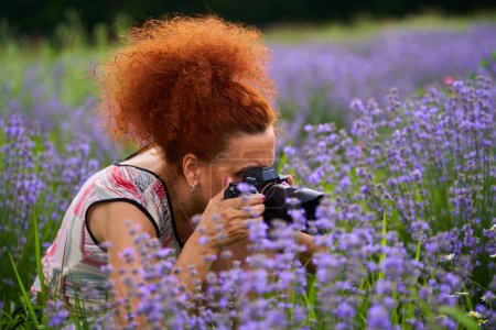 Téléchargez les photos : Femme photographe de nature avec son appareil photo dans un champ de lavande tournage de photos - en image libre de droit