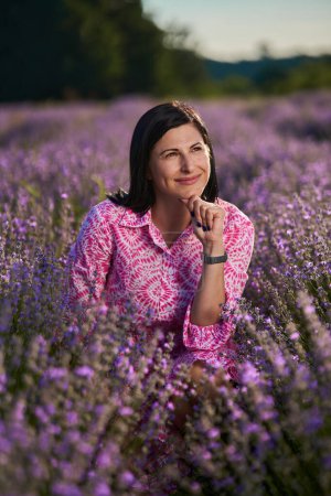 Photo for Attractive brunette young woman in a blooming lavender field - Royalty Free Image
