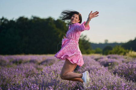 Téléchargez les photos : Jolie jeune femme brune dans un champ de lavande en fleurs - en image libre de droit