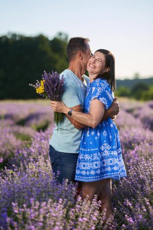 Photo for Romantic couple having a fragrant moment in a blooming lavender plantation - Royalty Free Image