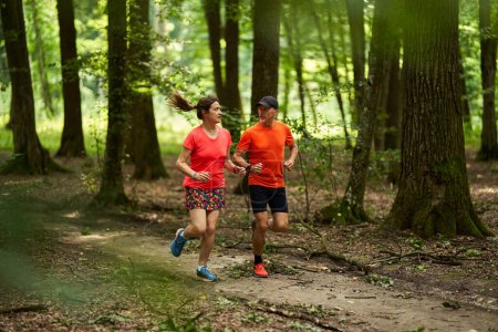 Foto de Corredores pareja resistencia corriendo en senderos forestales - Imagen libre de derechos