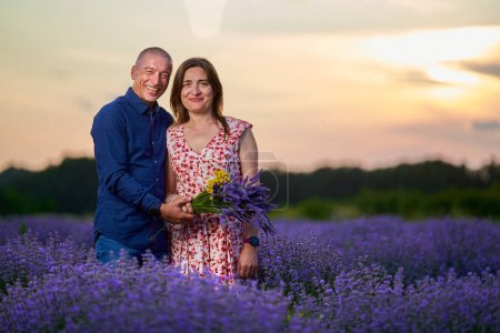 Téléchargez les photos : Portrait d'un couple romantique dans un champ de lavande au coucher du soleil - en image libre de droit