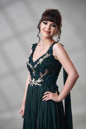 Foto de Primer plano de una elegante y hermosa mujer joven en vestido verde oscuro - Imagen libre de derechos