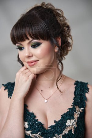 Photo for Closeup of an elegant beautiful young woman in dark green dress - Royalty Free Image