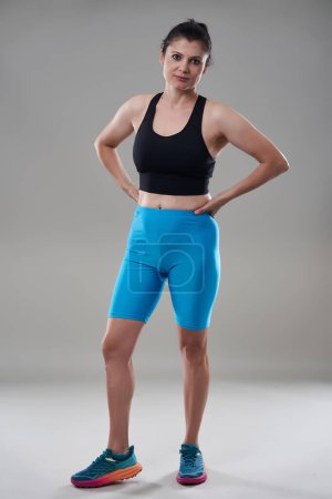 Téléchargez les photos : Mature brunette modèle de fitness isolé sur fond gris - en image libre de droit