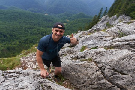 Foto de Hombre libre escalando sobre una roca de un acantilado en las montañas - Imagen libre de derechos