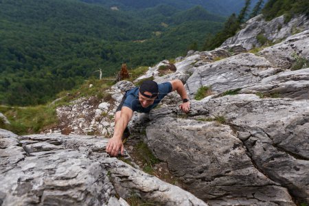 Téléchargez les photos : Homme escalade libre sur une paroi rocheuse d'une falaise dans les montagnes - en image libre de droit