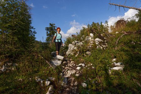 Téléchargez les photos : Femme avec sac à dos randonnée dans les montagnes sur un sentier - en image libre de droit